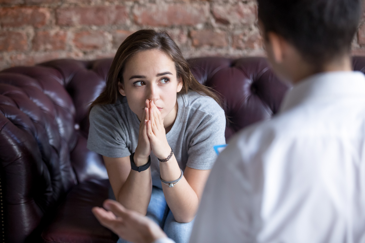 A person sitting on a couch lost in thought.